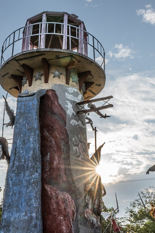 Decorated lighthouse in sculpture garden with sunburst