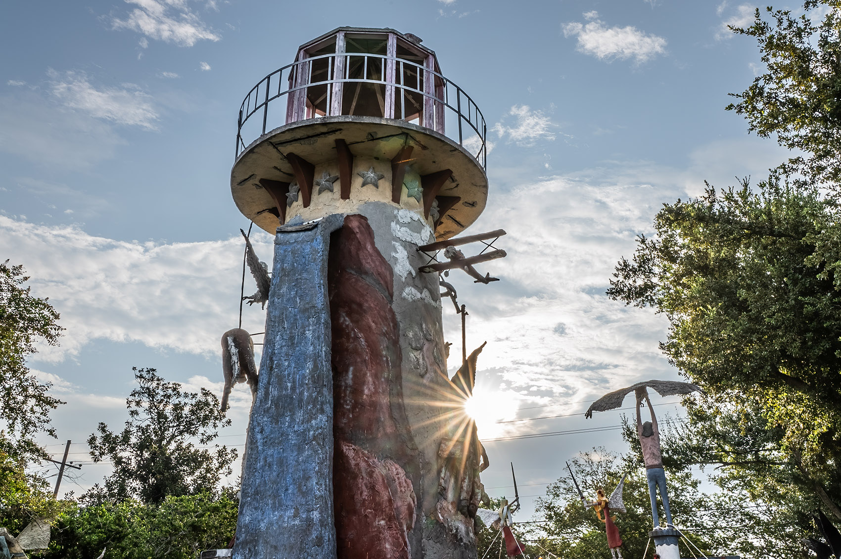 Decorated lighthouse in sculpture garden with sunburst