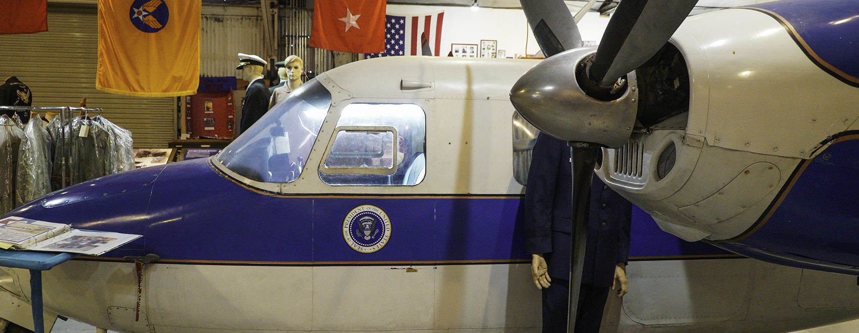 side view of propeller and cockpit of small Air Force One with presidential seal below window