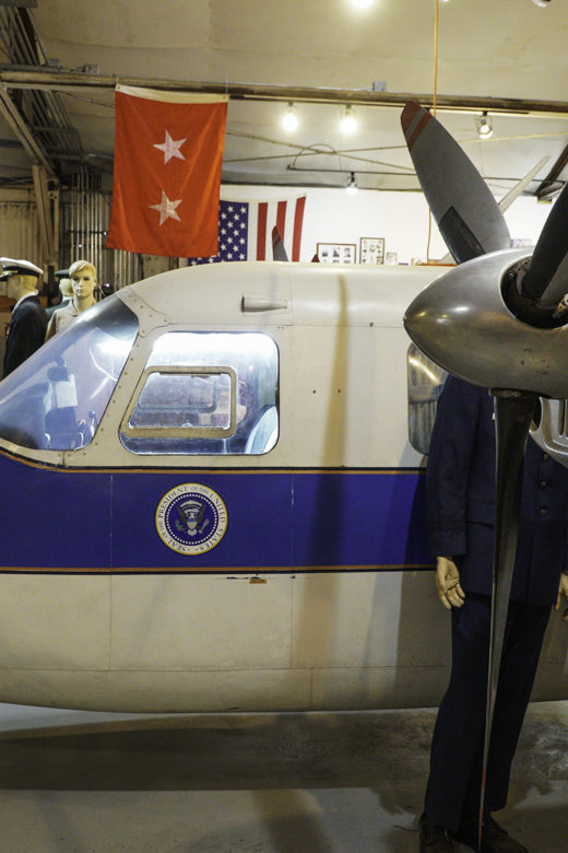 side view of propeller and cockpit of small Air Force One with presidential seal below window