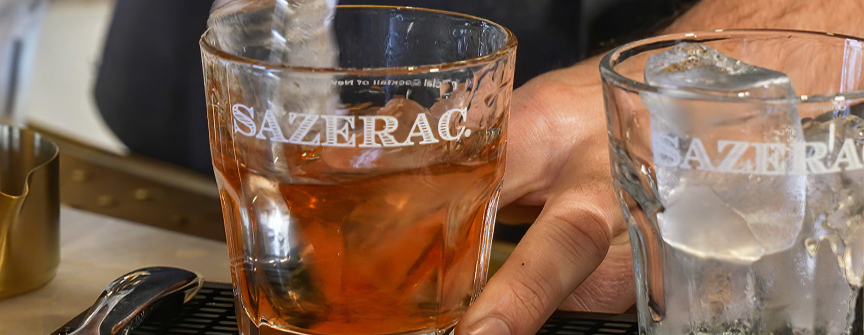 Sazerac cocktail on ice being stirred