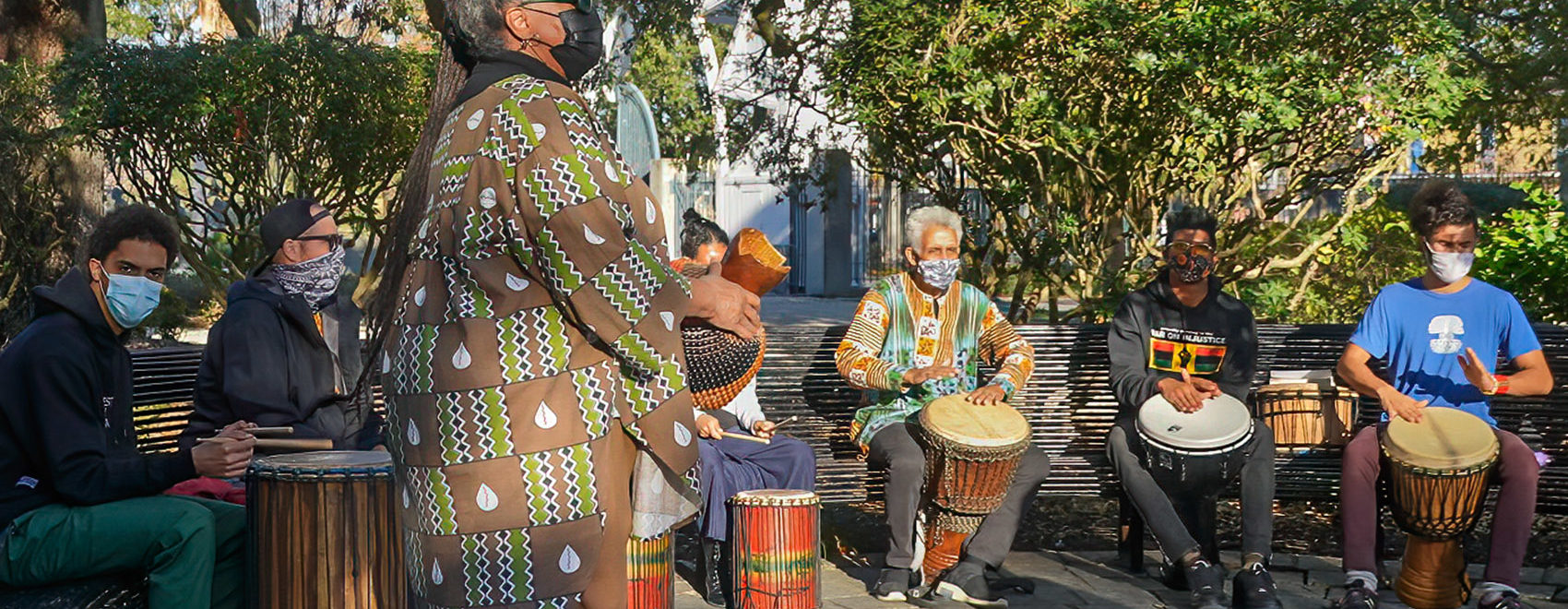 people sitting on bench playing congo drums in congo square in New Orleans
