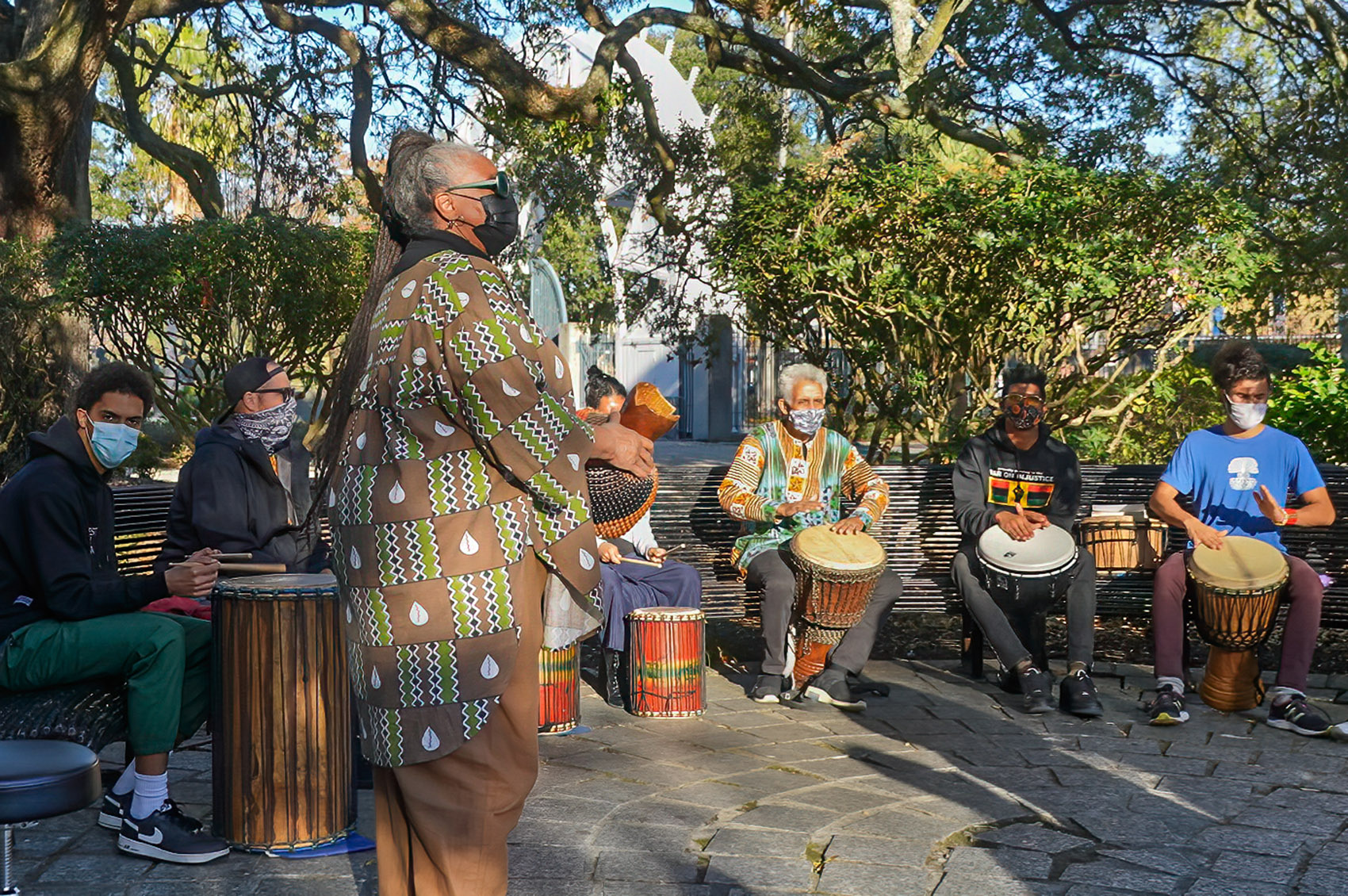 people sitting on bench playing congo drums in congo square in New Orleans