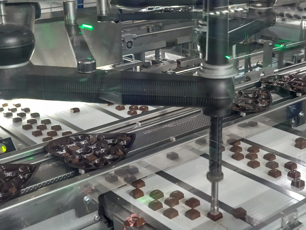 robotic arms load chocolate candy into heart shaped trays at Elmer Chocolate in Ponchatoula