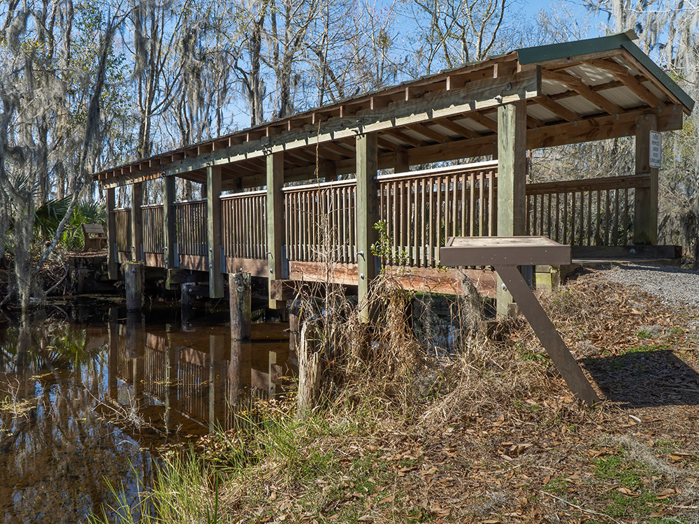 wooden covered bridge along the Mandalay nature trail where you can see Louisiana birds