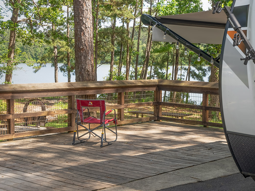 wood deck camper and chair among trees overlooking lake at south toledo bend state park