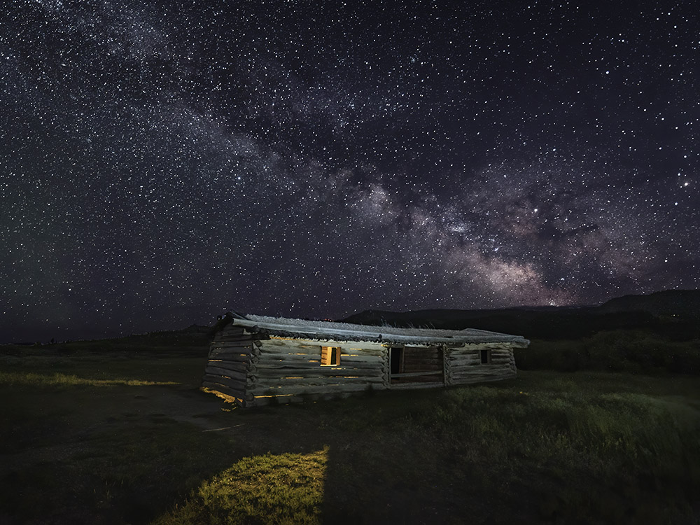 Milky Way above pioneer log cabin in Grand Teton National Park Utah