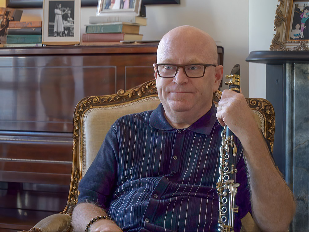 Jazz clarinetist Tim Laughlin sits in his home