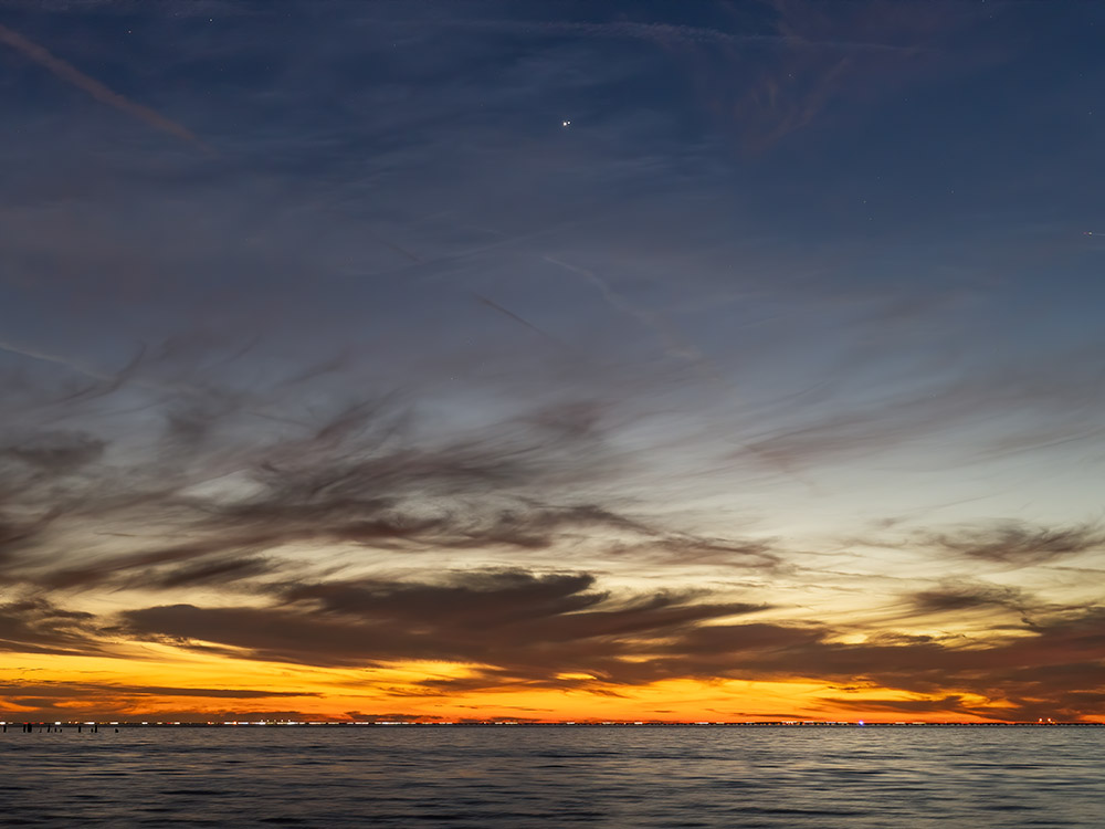 sunset afterglow above Lake Pontchartrain with great conjunction of Jupiter and Saturn high in dark sky