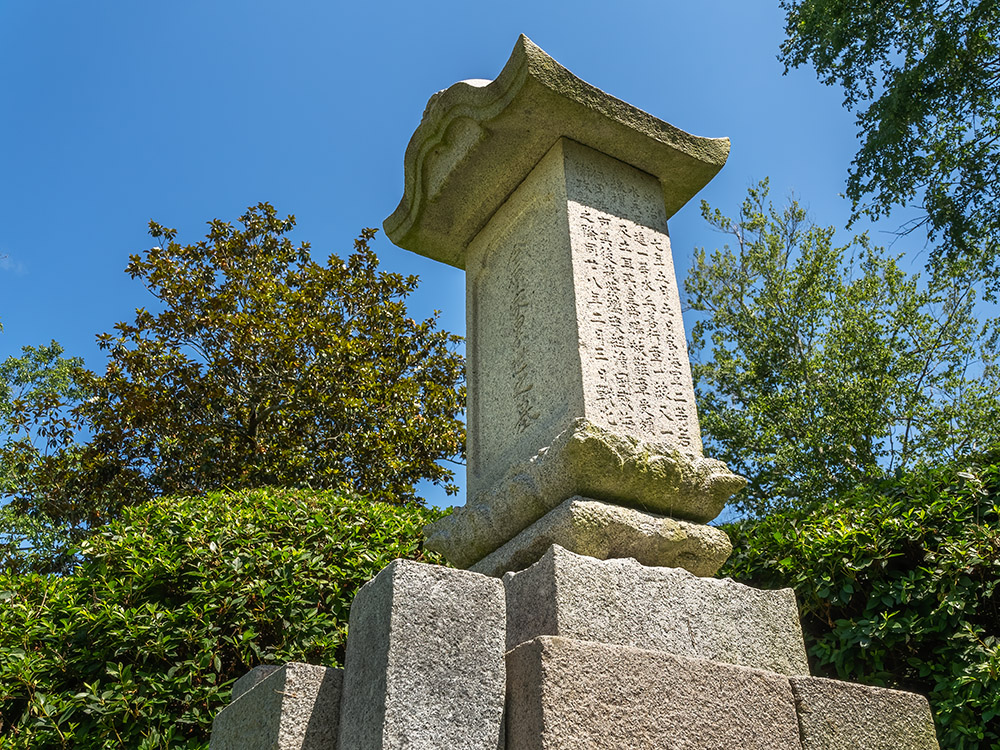 stone monument wth inscriptions in Japanese in garden