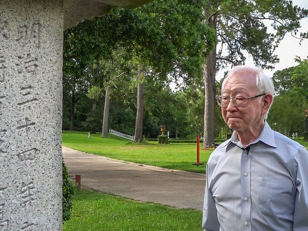 elderly gray haired man looks at japanese monument in saint francisville Louisiana