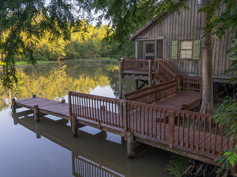 cabin with boat dock and fishing pier on bayou in Lake Fausse Pointe State Park Louisiana