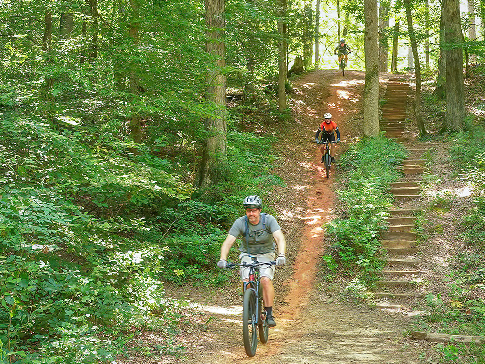 mountain bikers descend long sloping trail in Lincoln Parish Park Louisiana