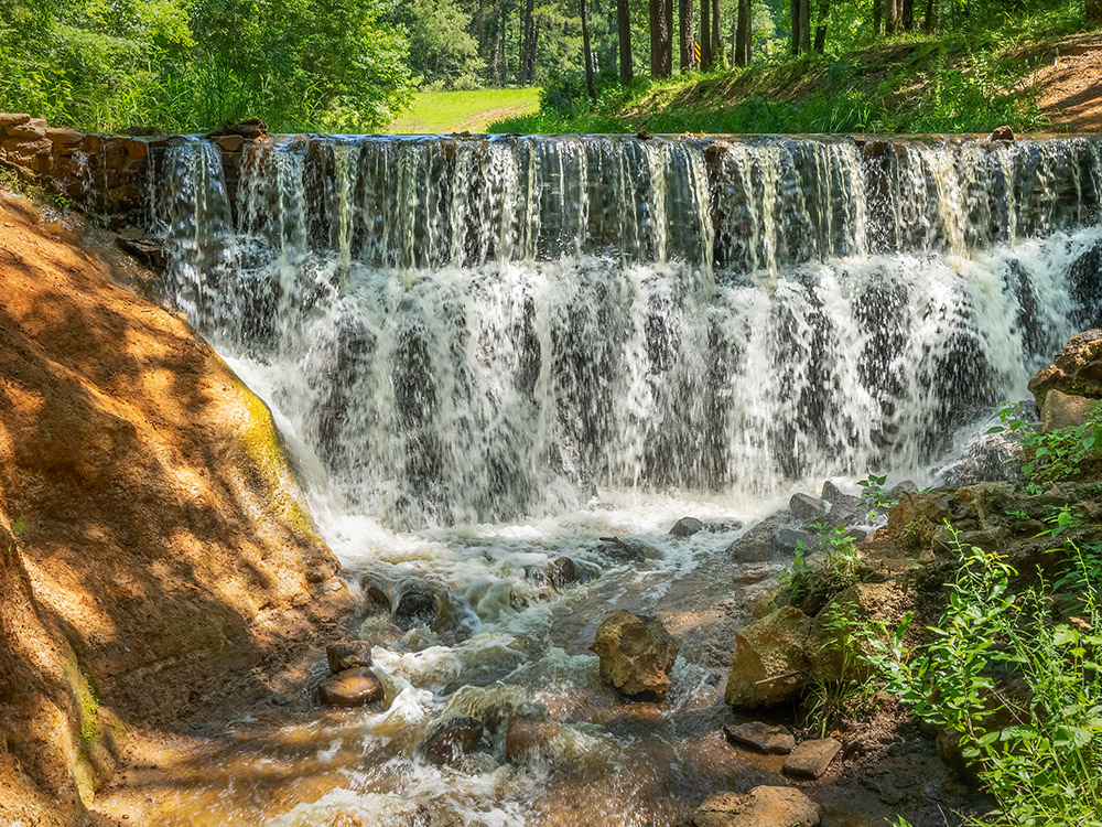 man-made waterfall feeds a rocky stream at Lincoln Parish Park