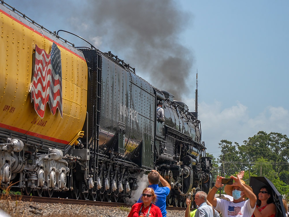 steam locomotive departing as people watch and take photos