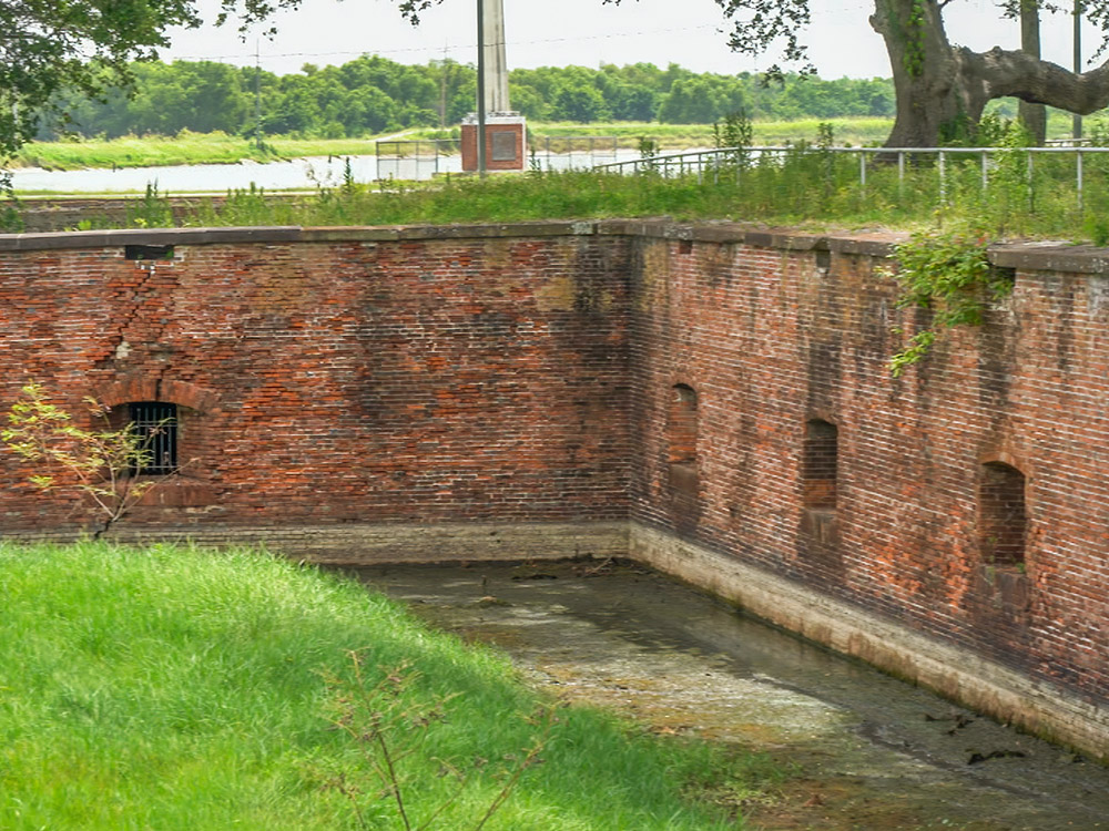 moat surrounds red brick walls of fort