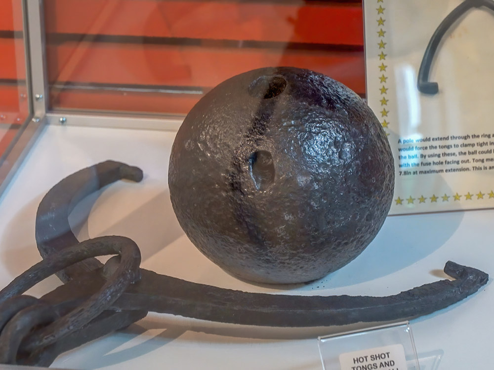 black cannon ball and iron tongs
