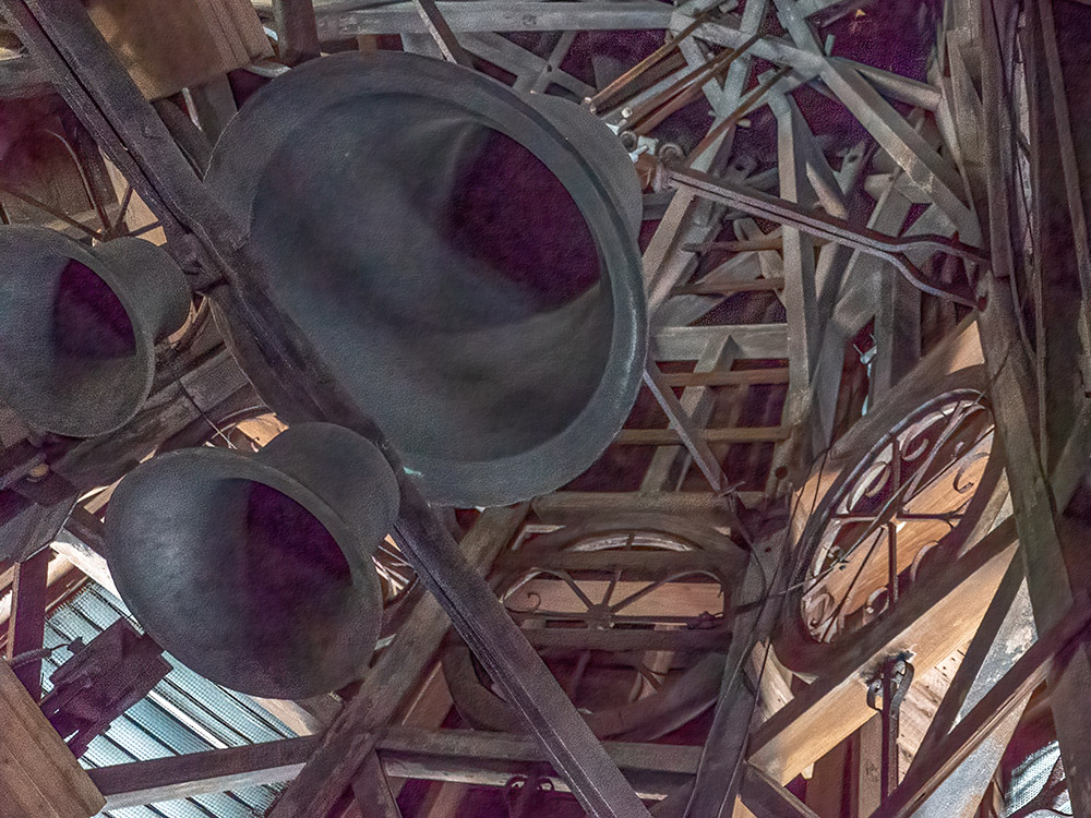 looking up at large bells inside church tower