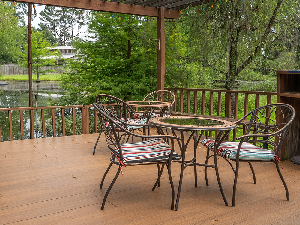 table and chairs on deck at small pond at shreveport wineries