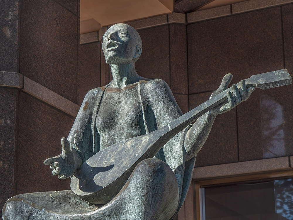 enrique alferez statue of lute player in front of building