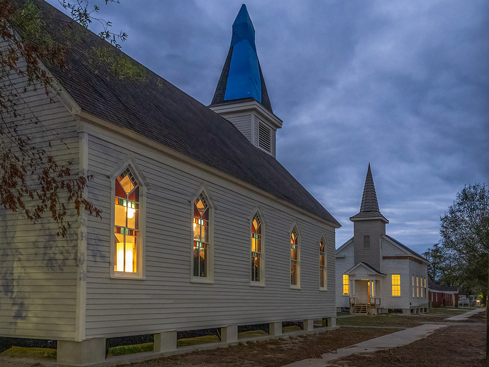 two wooden churches face each other after dark