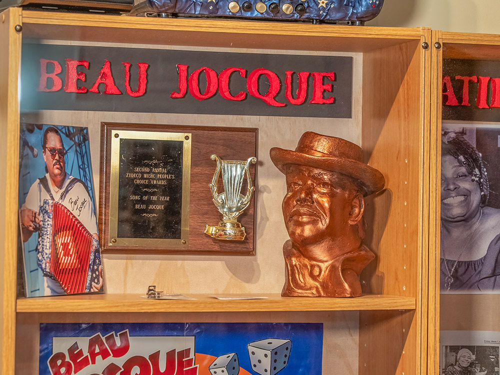 bronze bust of man in hat and other artifacts of zydeco musician Beau Jocque
