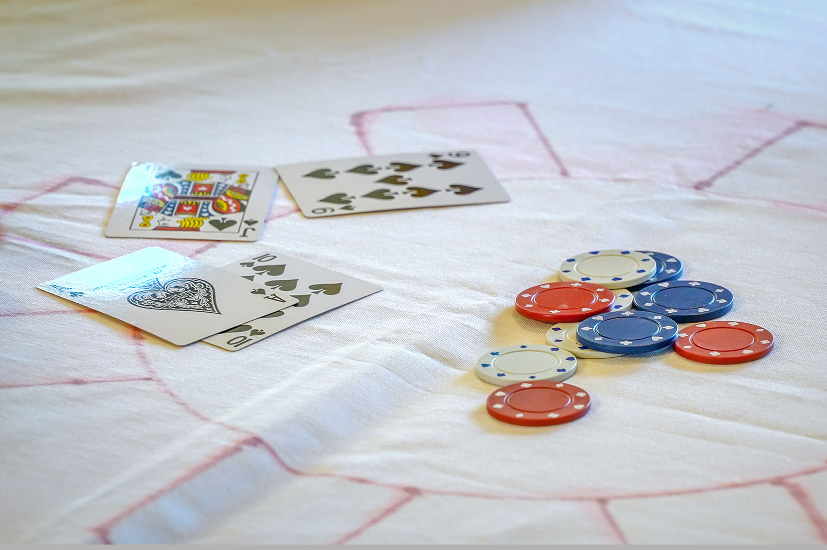 playing cards and chips on white table for bourre card game