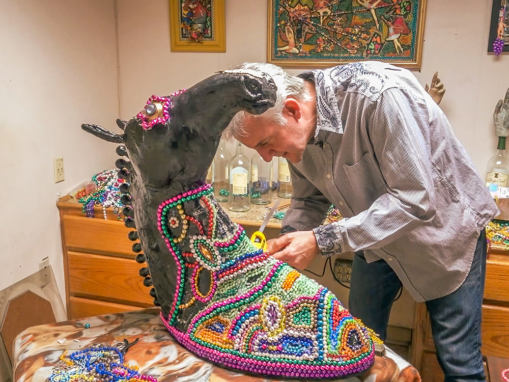 horse head shaped figure colored with colorful Mardi Gras beads by male artist