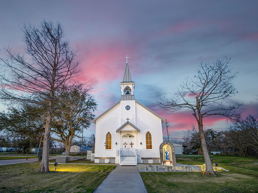 white church with steeple at twilight with pink clouds