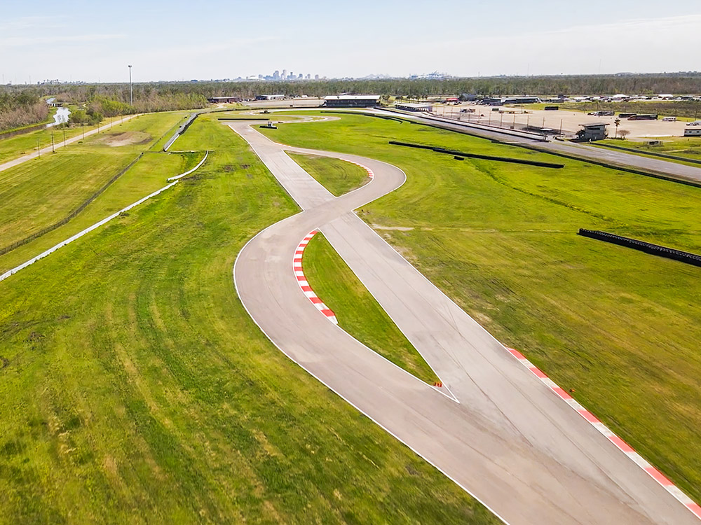 aerial view of motor speedway with skyline of New Orleans in the background