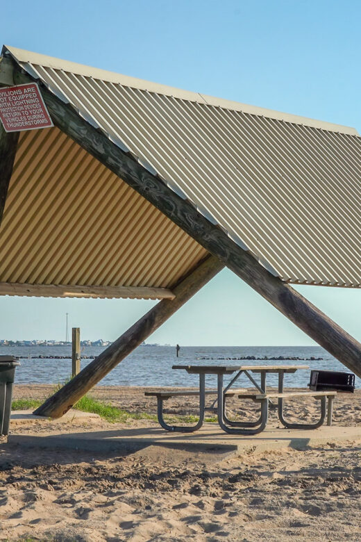 A fram shaped beach pavilion on sand near water at Cypremort Point