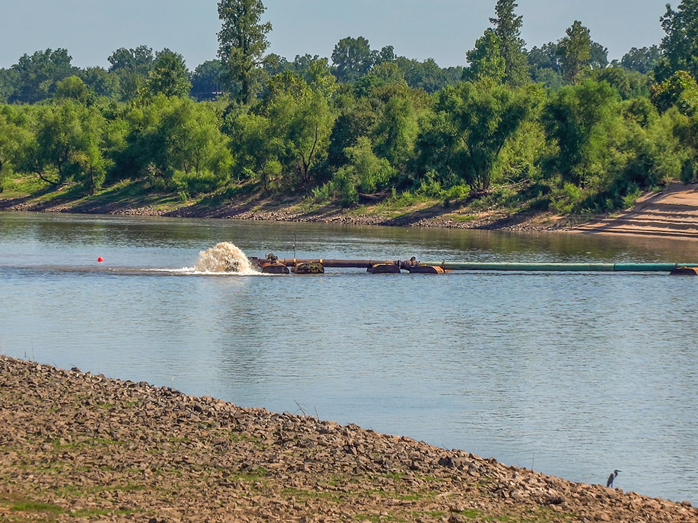pipe for river dredge spews water in red river