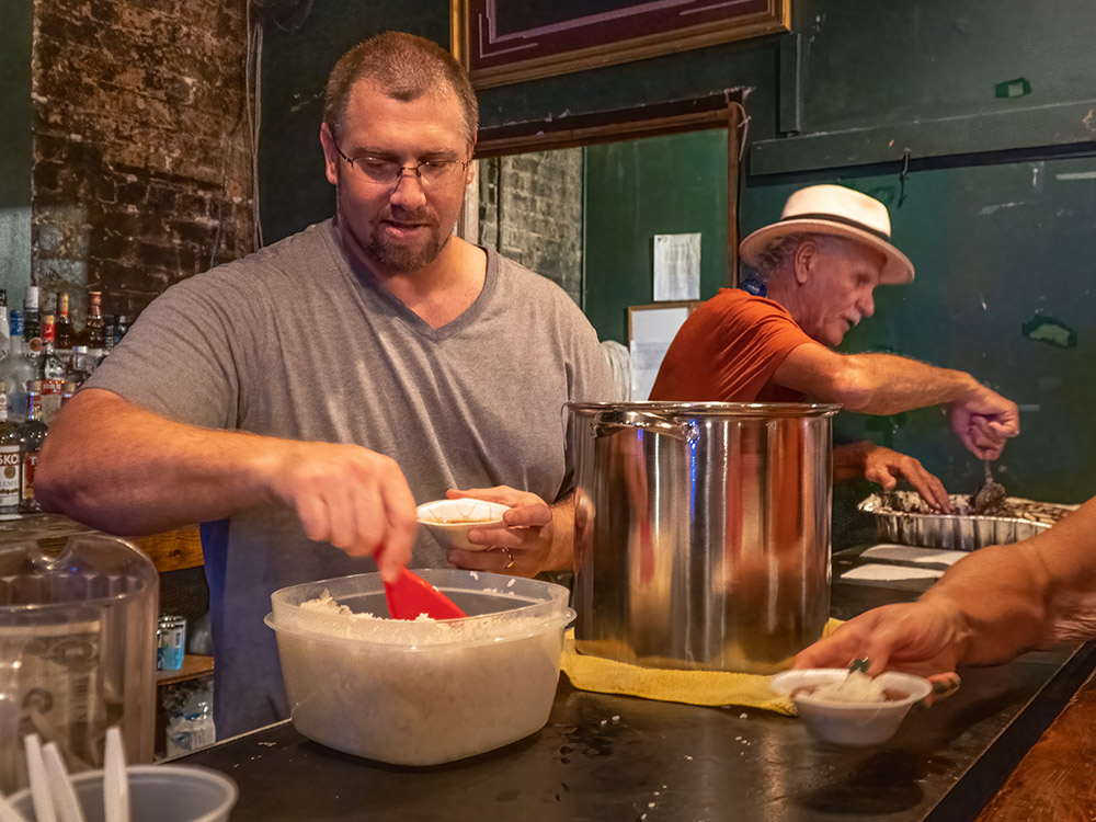 two men serve red beans and rice at Tipitina's fais-dodo