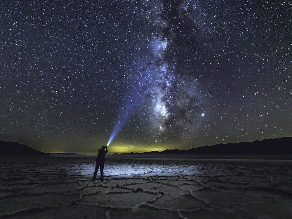 milky way and man with flashlight in Death Valley