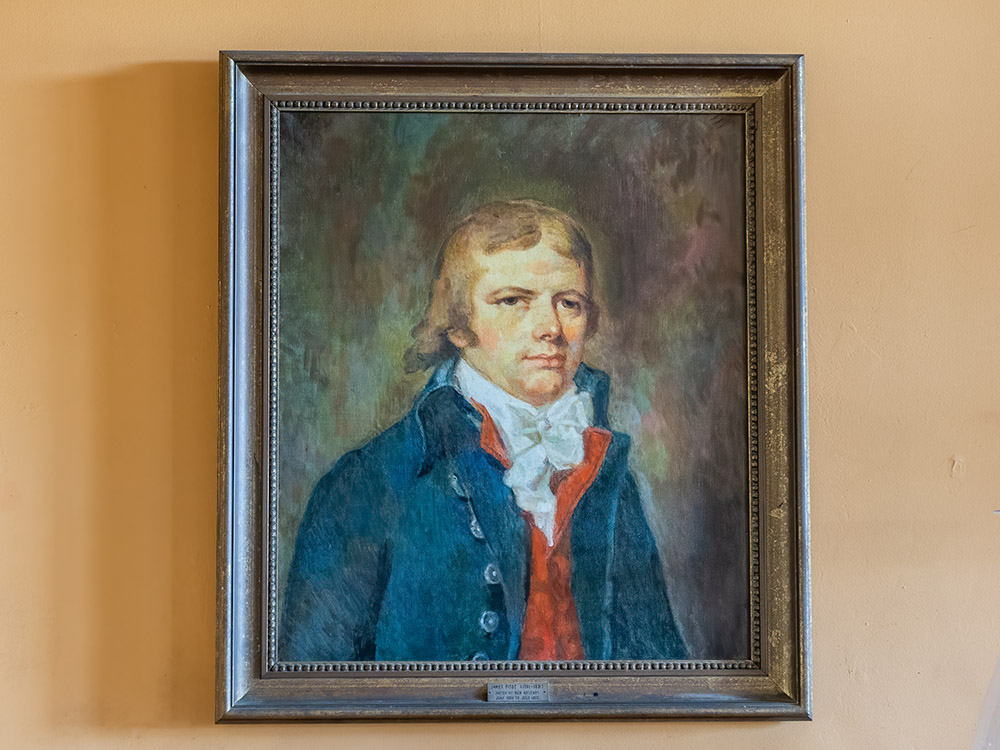 painting of colonial era man in blue coat with red vest.