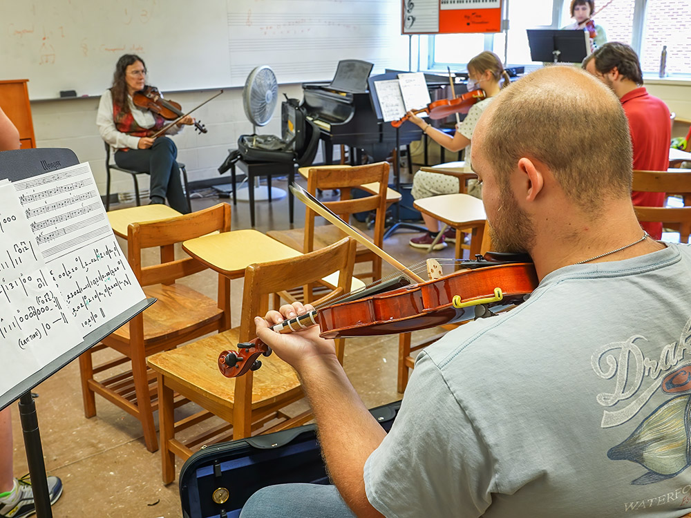 students and instructor play fiddle in traditional music class
