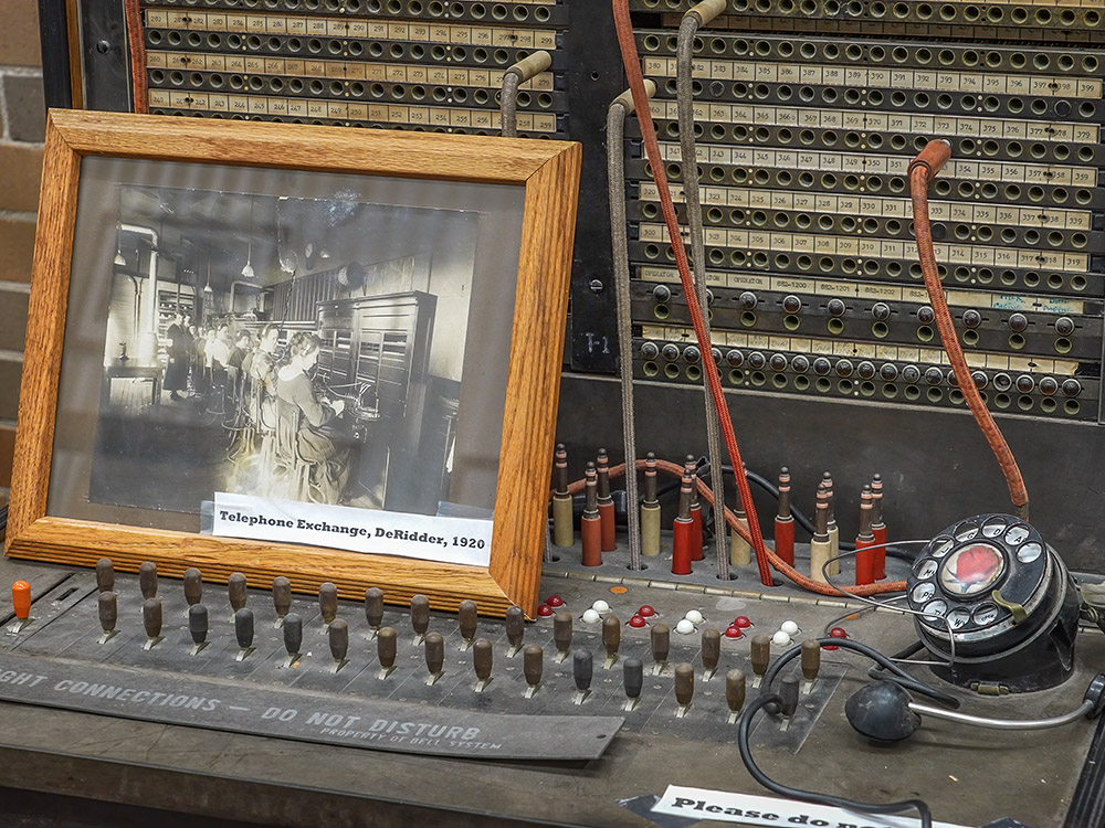 antique telephone exchange with dial and patch panel and cords and photograph