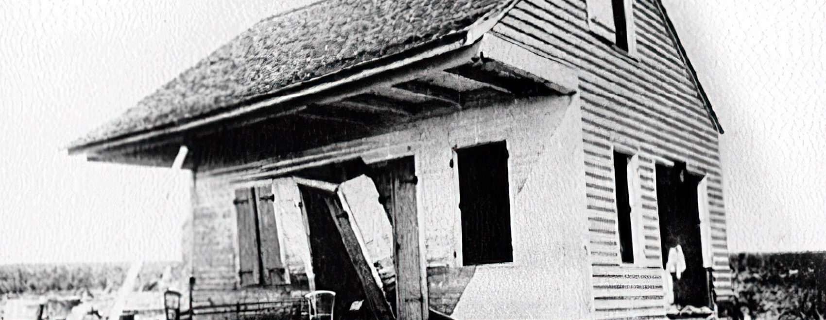 old wooden house with hurricane damage in black and white