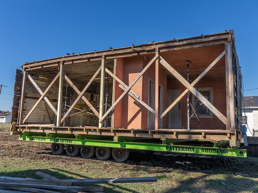 old wooden house cut in half and loaded on trailer for transport