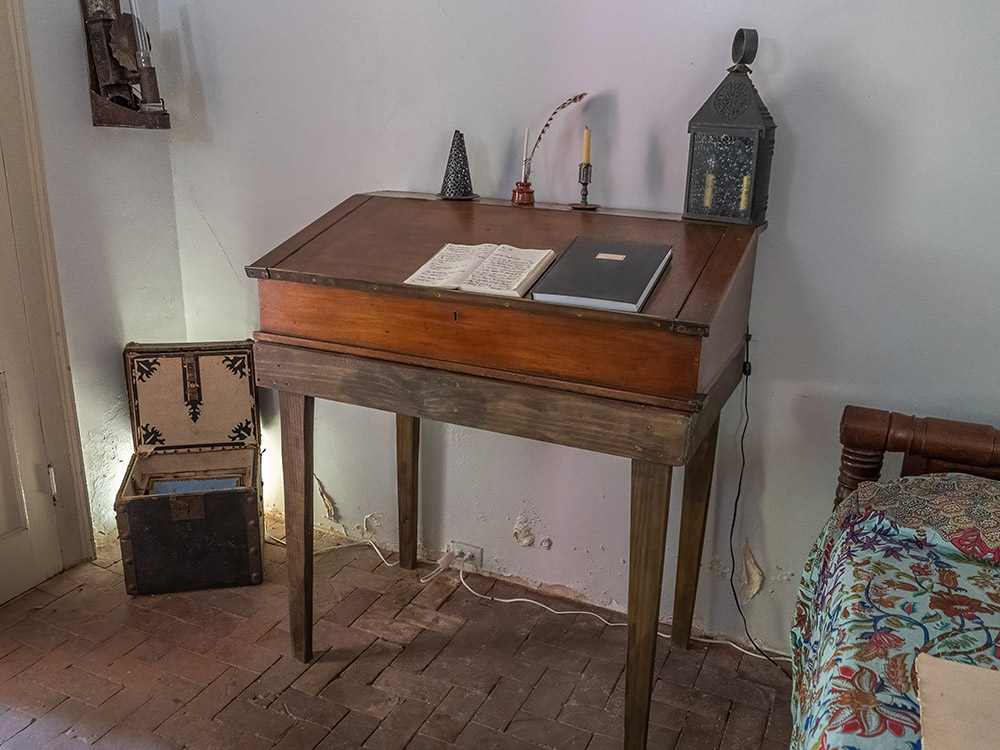antique wooden standing desk with paper, book, quill pen and ink.