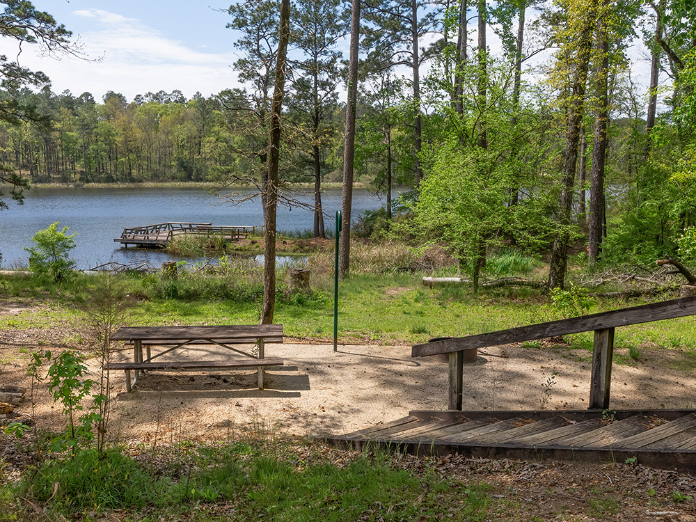 wooden steps to campsite and picnic table overlooking fishing pier in Valentine Lake