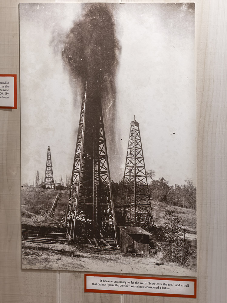 black and white photograph of gusher at oil well

