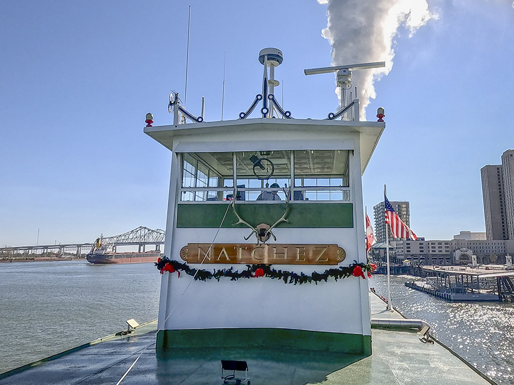 steamboat Natchez on river in New Orleans blowing steam whistle