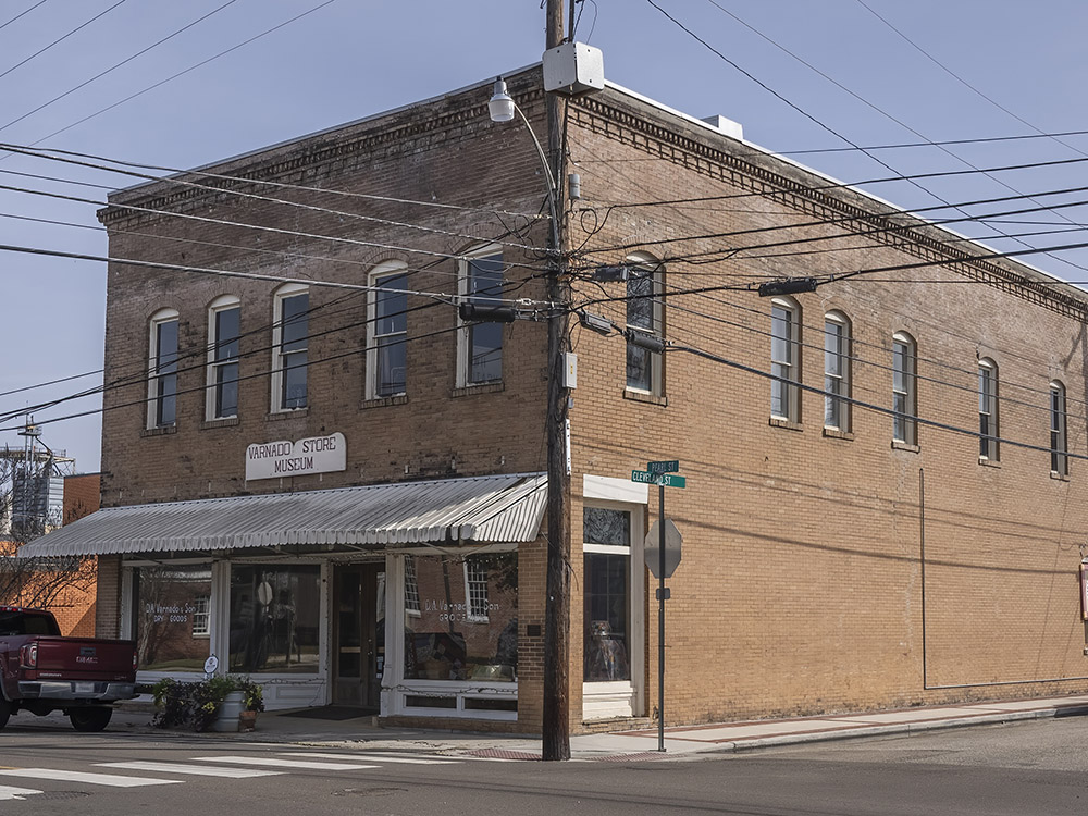 two story brick building on street corner with sign Varnado store museum