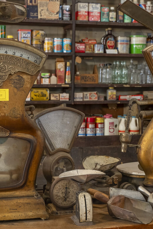 two antique scales in front of store shelves in old time general store