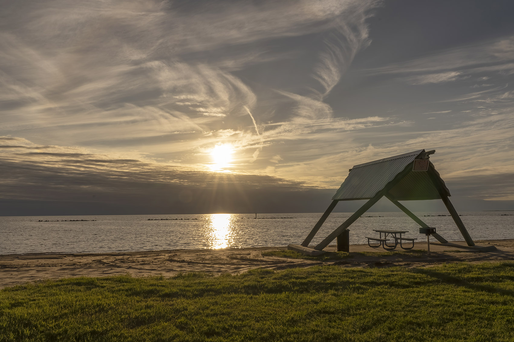 sunset along beach with picnic table and canopy
