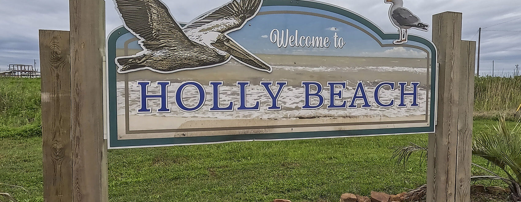 wood sign with pelican and welcome to Holly Beach