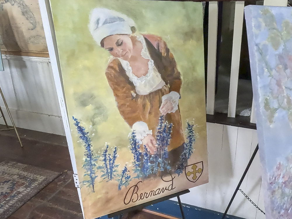 Acadian woman in portrait picking purple flowers