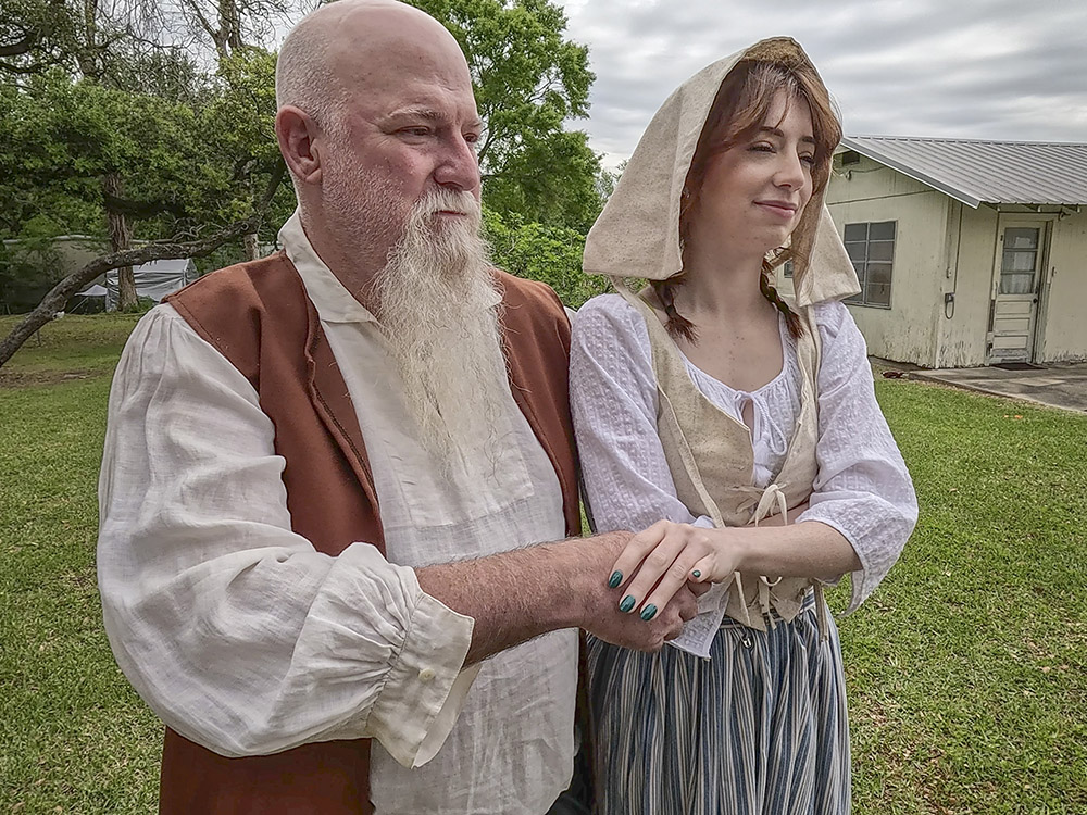 man with gray beard and young woman dressed in historic clothing