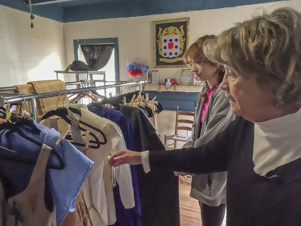 women look through rack of vintage clothing